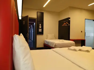 a hotel room with two beds and a closet at Hotel Regal Vista in Ipoh