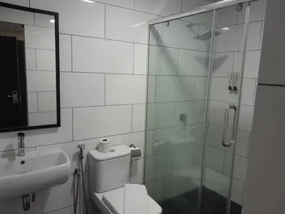a bathroom with a shower and a toilet and a sink at Hotel Regal Vista in Ipoh