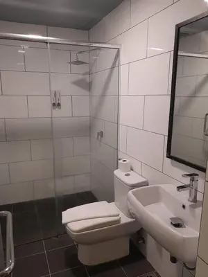 a bathroom with a toilet and a sink and a shower at Hotel Regal Vista in Ipoh