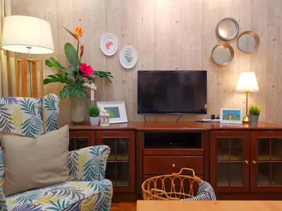 a living room with a television on a wooden entertainment center at Green Hill Tanah Rata Cameron Highland in Tanah Rata