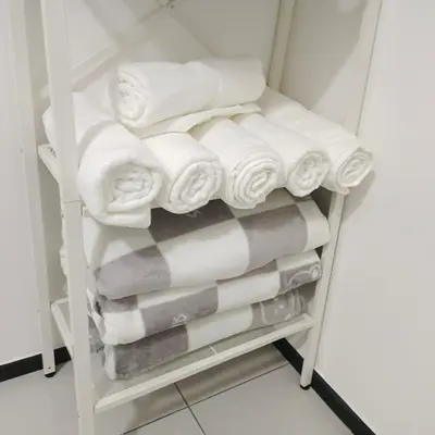 a stack of towels on a towel rack in a bathroom at Veneto Penang homestay 3BR with infinity pool in Jelutong