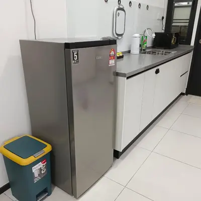 a kitchen with a refrigerator and a trash can at Veneto Penang homestay 3BR with infinity pool in Jelutong