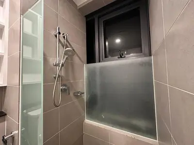 a bathroom with a shower with a glass door at Tropicana 218 Macalister WL in George Town