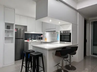 a kitchen with white cabinets and black bar stools at Tropicana 218 Macalister WL in George Town