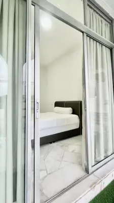 a room with a bed and a glass window at Three Homestay in Perai