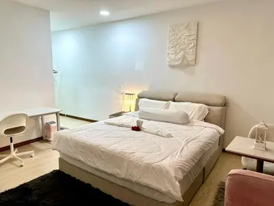a bedroom with a white bed with a desk and a chair at Three Homestay in Perai