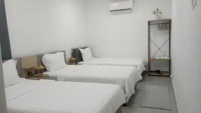 a room with three beds with white sheets at Three Homestay in Perai