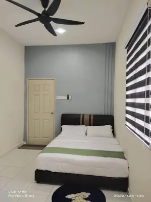 a bedroom with a bed with a ceiling fan at Homestay Mewah Lumut in Lumut