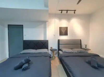 two beds sitting next to each other in a bedroom at 3 Storey Bangalow near Spice Arena & Queensbay Mall in Bayan Lepas