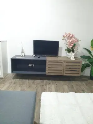 a living room with a flat screen tv on a cabinet at 3 Storey Bangalow near Spice Arena & Queensbay Mall in Bayan Lepas