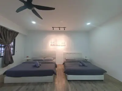a bedroom with two beds and a ceiling fan at 3 Storey Bangalow near Spice Arena & Queensbay Mall in Bayan Lepas