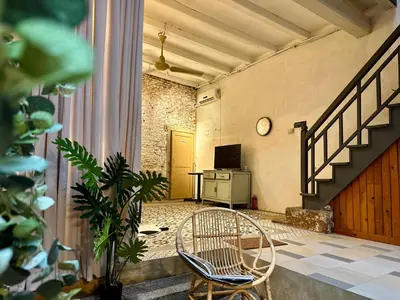 a room with a chair and a table and a clock at (New) Eternal Granpa’s heritage(UNESCO)/11pax/3BR in George Town