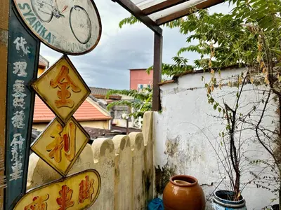 a clock on a pole next to a fence at (New) Eternal Granpa’s heritage(UNESCO)/11pax/3BR in George Town