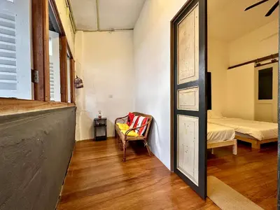 a room with a door and a chair and a bed at (New) Eternal Granpa’s heritage(UNESCO)/11pax/3BR in George Town