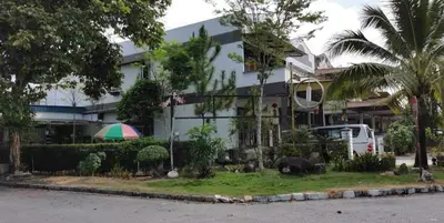 a white building with an umbrella in front of it at Lung Tok Entreprise \u8336\u9986\u6c11\u5bbf in Bukit Mertajam
