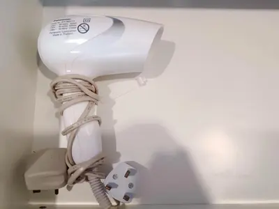 a white hair dryer is attached to a wall at Lung Tok Entreprise \u8336\u9986\u6c11\u5bbf in Bukit Mertajam