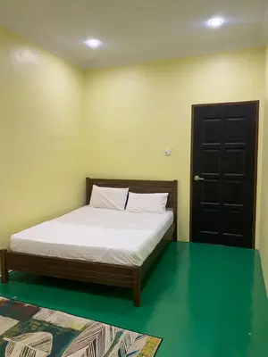 a bedroom with a bed with white sheets and a door at Fadlim Homestay in Padang Serai