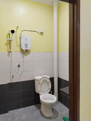 a bathroom with a toilet and a shower at Fadlim Homestay in Padang Serai