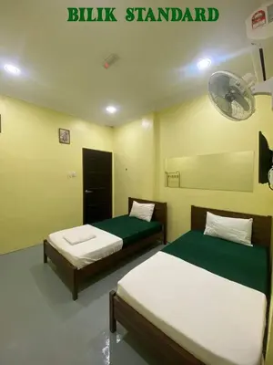 a bedroom with two beds and a sign that reads blitz standard at Fadlim Homestay in Padang Serai