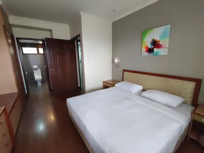 a bedroom with a large white bed in a room at Sunrise View One Bedroom Apartment at Equatorial Hill Resort in Brinchang