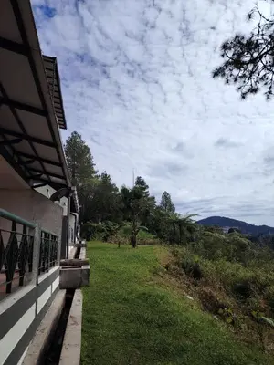 a porch of a house with a view of a field at Sunrise View One Bedroom Apartment at Equatorial Hill Resort in Brinchang