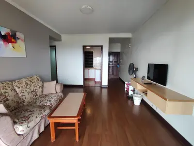 a living room with a couch and a table at Sunrise View One Bedroom Apartment at Equatorial Hill Resort in Brinchang
