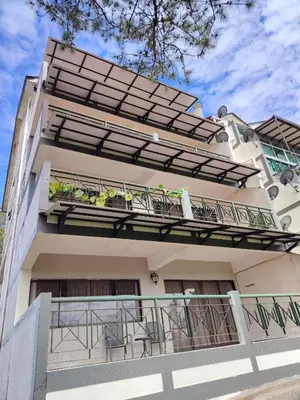 a building with a balcony with tables and chairs at Sunrise View One Bedroom Apartment at Equatorial Hill Resort in Brinchang