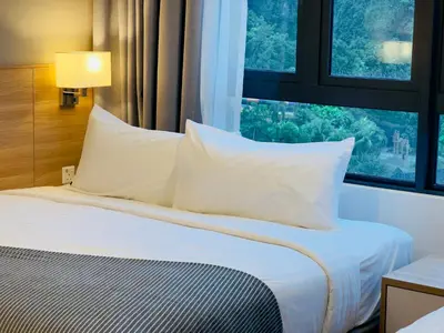 a bedroom with a bed with white pillows and a window at Hygge Living@Sunway Onsen in Tambun