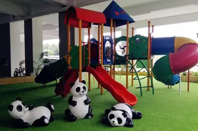 three pandas sitting on the ground in a playground at 5D Homestay in Sitiawan