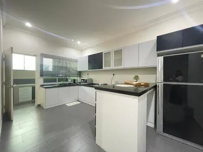 a kitchen with white cabinets and a black counter top at Art Homestay 4 Bedrooms House by Mr Homestay in Teluk Intan