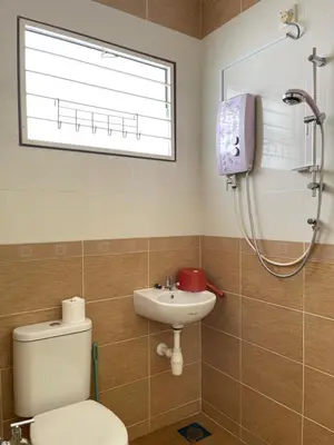 a bathroom with a toilet and a sink and a window at Art Homestay 4 Bedrooms House by Mr Homestay in Teluk Intan