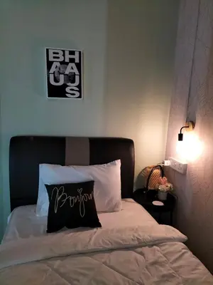 a bed with a black and white pillow on it at Le Melur Single Bed in George Town