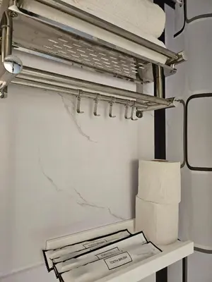 a towel rack with towels and a pile of paper towels at Le Melur Single Bed in George Town