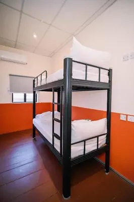 two bunk beds in a room with an orange wall at Swing & Pillows - 75 Chulia St, Georgetown Penang in George Town