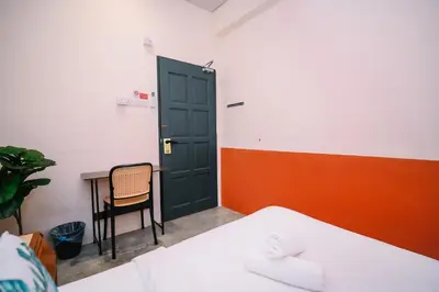 a room with a door and a table and a chair at Swing & Pillows - 75 Chulia St, Georgetown Penang in George Town