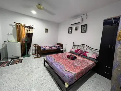a bedroom with a bed and a couch and a bed sidx sidx sidx at Nipah Medium Roomstay Parit Buntar in Parit Buntar