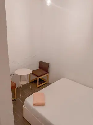 a bedroom with a bed and a chair and a table at Goodnight Homestay in George Town
