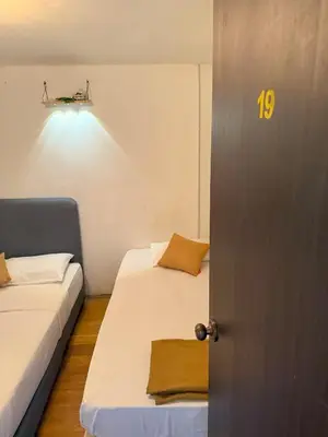 a door to a room with two beds and a light at Goodnight Homestay in George Town