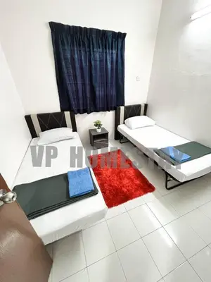 a bedroom with two beds and a red rug at VP Homestay - Malay Only in Ipoh
