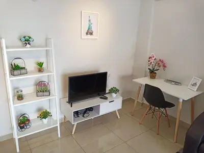 a living room with a television and a table and a desk at Georgetown, Up to 6 Pax, 3 Bedrooms, 1 Car Park by Star Home in Jelutong