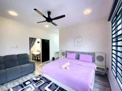 a bedroom with a large bed and a couch at Modern Cozy House 4Room10pax @Near Sunway Carnival in Perai
