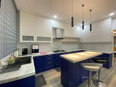 a kitchen with blue and white cabinets and a bar stool at Modern Cozy House 4Room10pax @Near Sunway Carnival in Perai