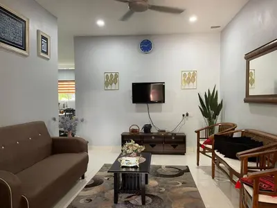 a living room with a couch and a tv at Homestay Warisan Abang Tam in Kepala Batas