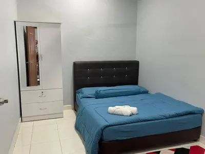 a bedroom with a blue bed with a black headboard at Homestay Warisan Abang Tam in Kepala Batas