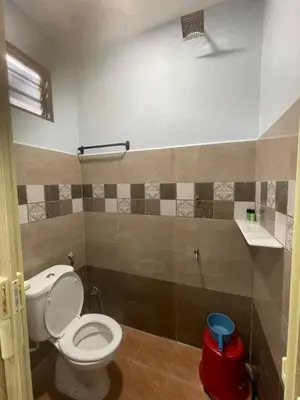 a bathroom with a white toilet in a room at Homestay Warisan Abang Tam in Kepala Batas