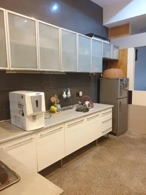 a kitchen with white cabinets and a refrigerator at Chor Residence Homestay in Ipoh