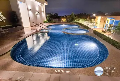 a large swimming pool at night with blue tiles at Premium Holiday Suite beside Lost World Tambun at Sunway Onsen in Tambun