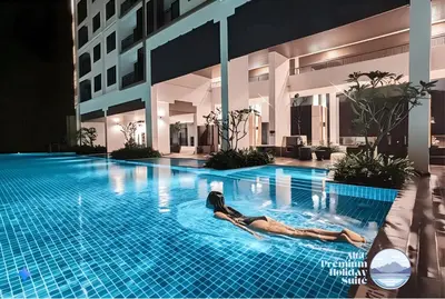 a woman laying in a swimming pool at night at Premium Holiday Suite beside Lost World Tambun at Sunway Onsen in Tambun