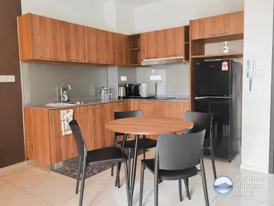 a kitchen with a wooden table and black chairs at Premium Holiday Suite beside Lost World Tambun at Sunway Onsen in Tambun