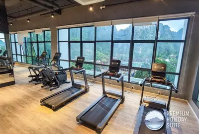 a gym with a row of treadmills and windows at Premium Holiday Suite beside Lost World Tambun at Sunway Onsen in Tambun